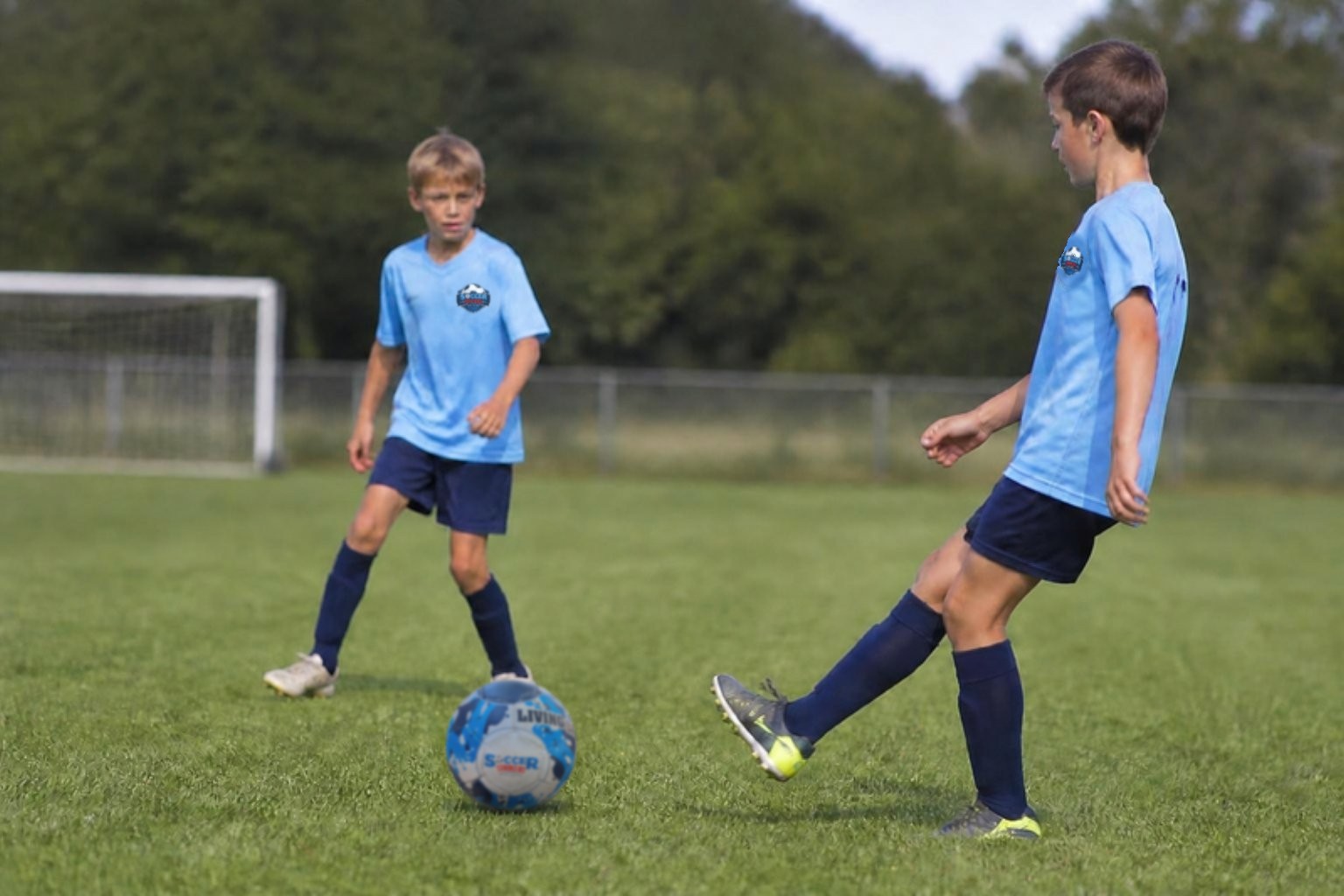 Two young players passing the Soccer Strikers ball on the field